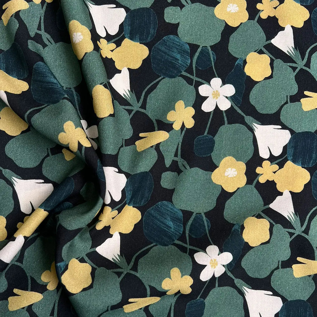 Viscose Challis fabric featuring Capucine flowers pattern in black, green, and yellow, perfect for dresses, skirts, and blouses.