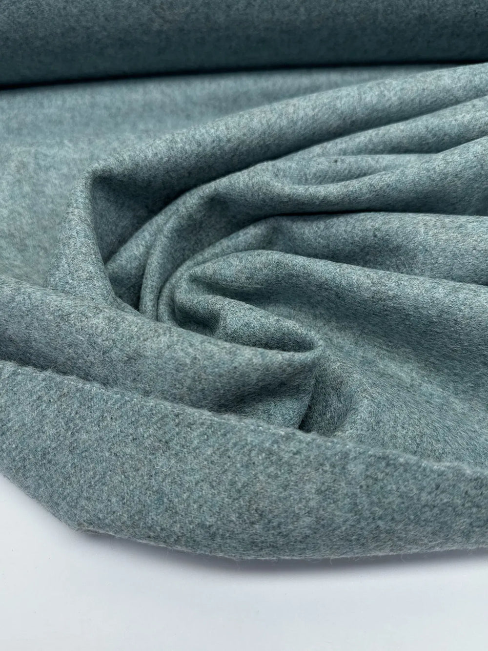 Close-up of Wool Suiting fabric in mottled slate blue, made from 100% high-quality wool, ideal for tailored suits and coats.