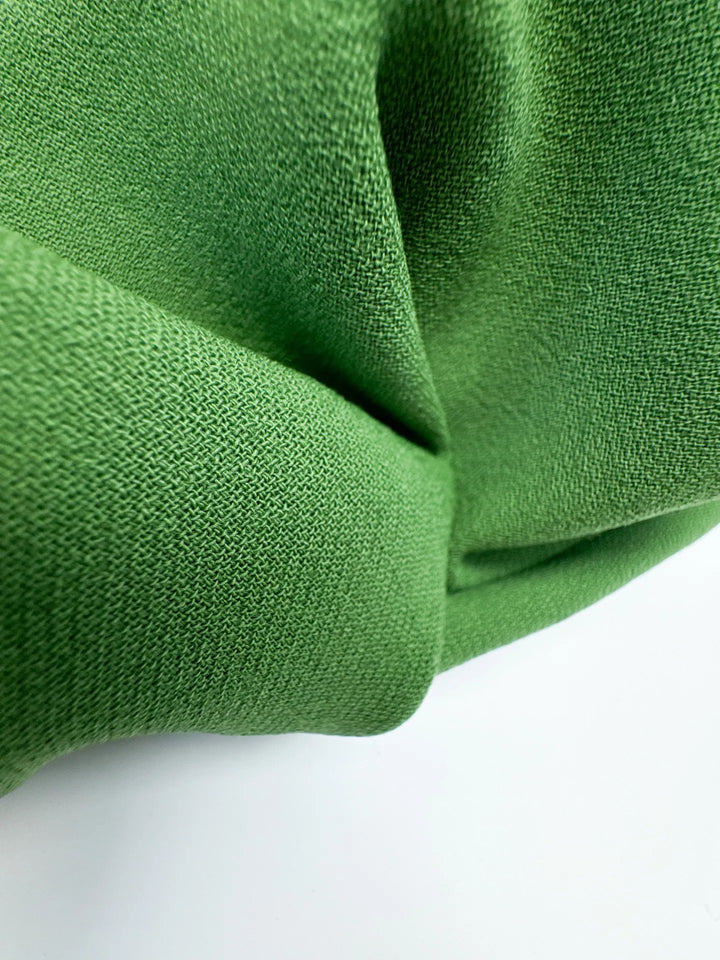 Luxurious Italian grass green wool twill fabric, perfect for coats, blazers, and suiting with strength, warmth, and timeless style.