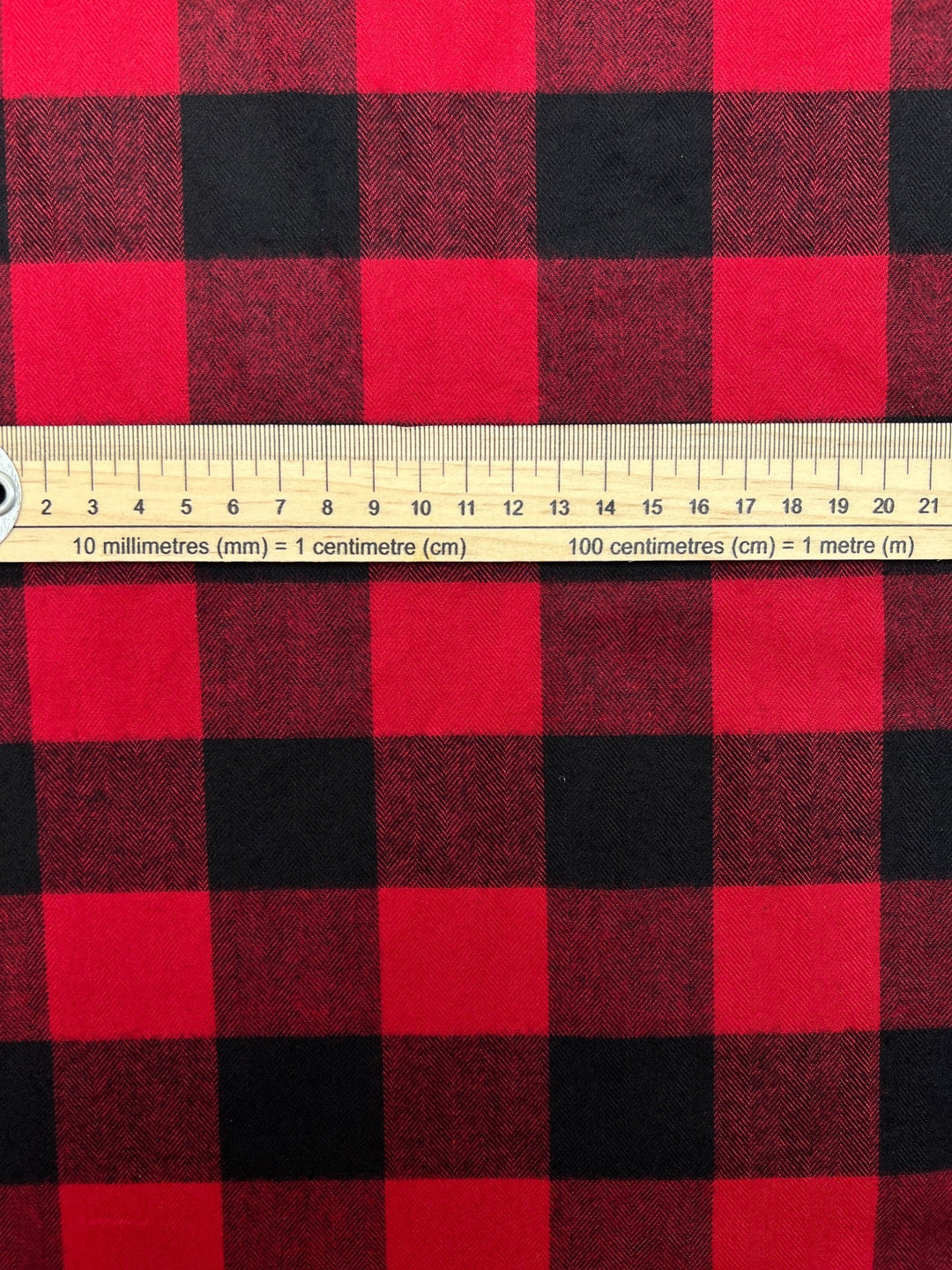 Italian cotton flannel fabric in red and black buffalo plaid, lightweight textile ideal for shirts, blouses, and casual wear.
