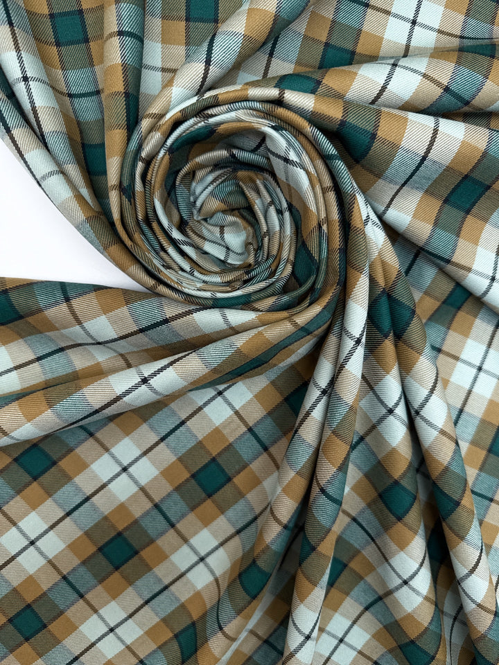 Italian cotton tweed fabric in cream, green, and brown plaid twill weave, lightweight and structured for coats, suiting, and dresses.