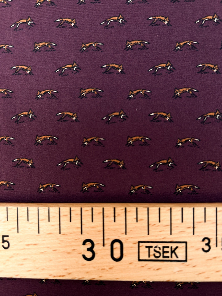 Dressweight Woven fabric in eggplant purple with tiny fox motifs. Made from 95% Polyamide and 5% Elastane. Ideal for dresses, skirts, and blouses.