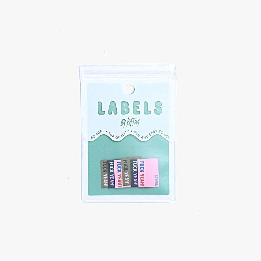 F*ck Yeah woven labels by Kylie and the Machine showing three color variations: black/blue/purple, khaki/black/pink, and pink/navy/rust side seam tags