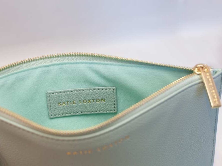 Everyday wristlet clutch in neutral color with removable strap and minimalist design.