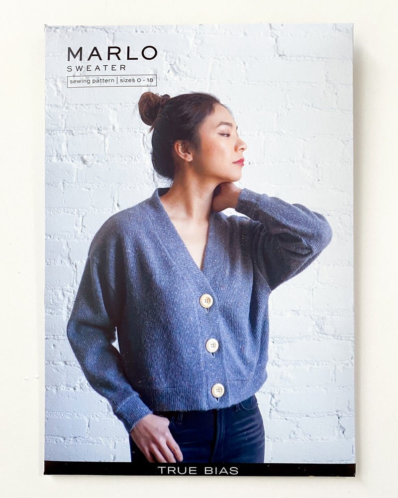 True Bias Marlo Sweater in medium-weight knit, featuring dropped shoulder, deep V-neck, wide bands, and large buttons, shown in cropped and mid-thigh length views.