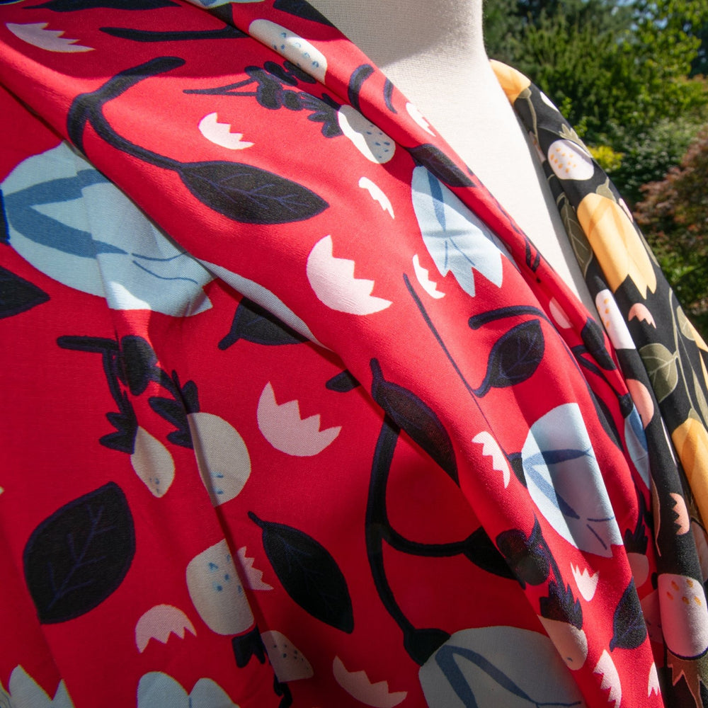 Rayon Poplin fabric with blue floral pattern on red background, 100% lightweight, soft and drapable, ideal for sewing projects.