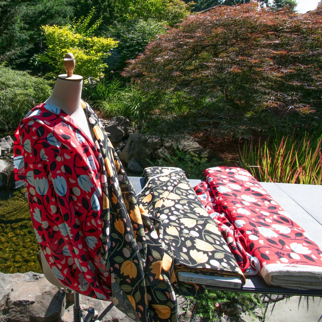 Rayon Poplin fabric with blue floral pattern on red background, 100% lightweight, soft and drapable, ideal for sewing projects.
