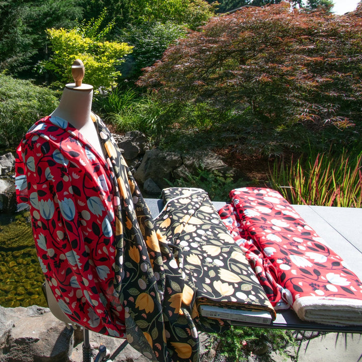 Rayon Poplin fabric with blue floral pattern on red background, 100% lightweight, soft and drapable, ideal for sewing projects.