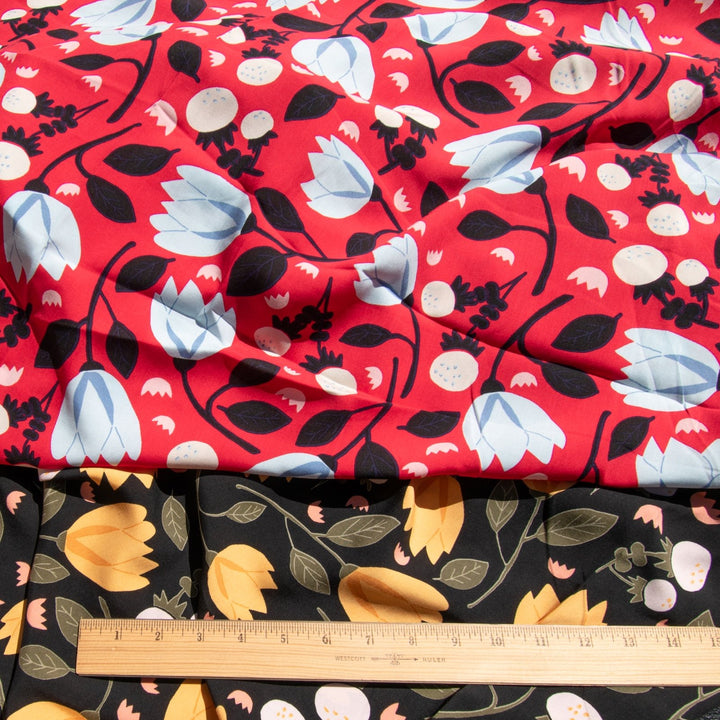 Rayon Poplin fabric with blue floral pattern on red background, 100% lightweight, soft and drapable, ideal for sewing projects.