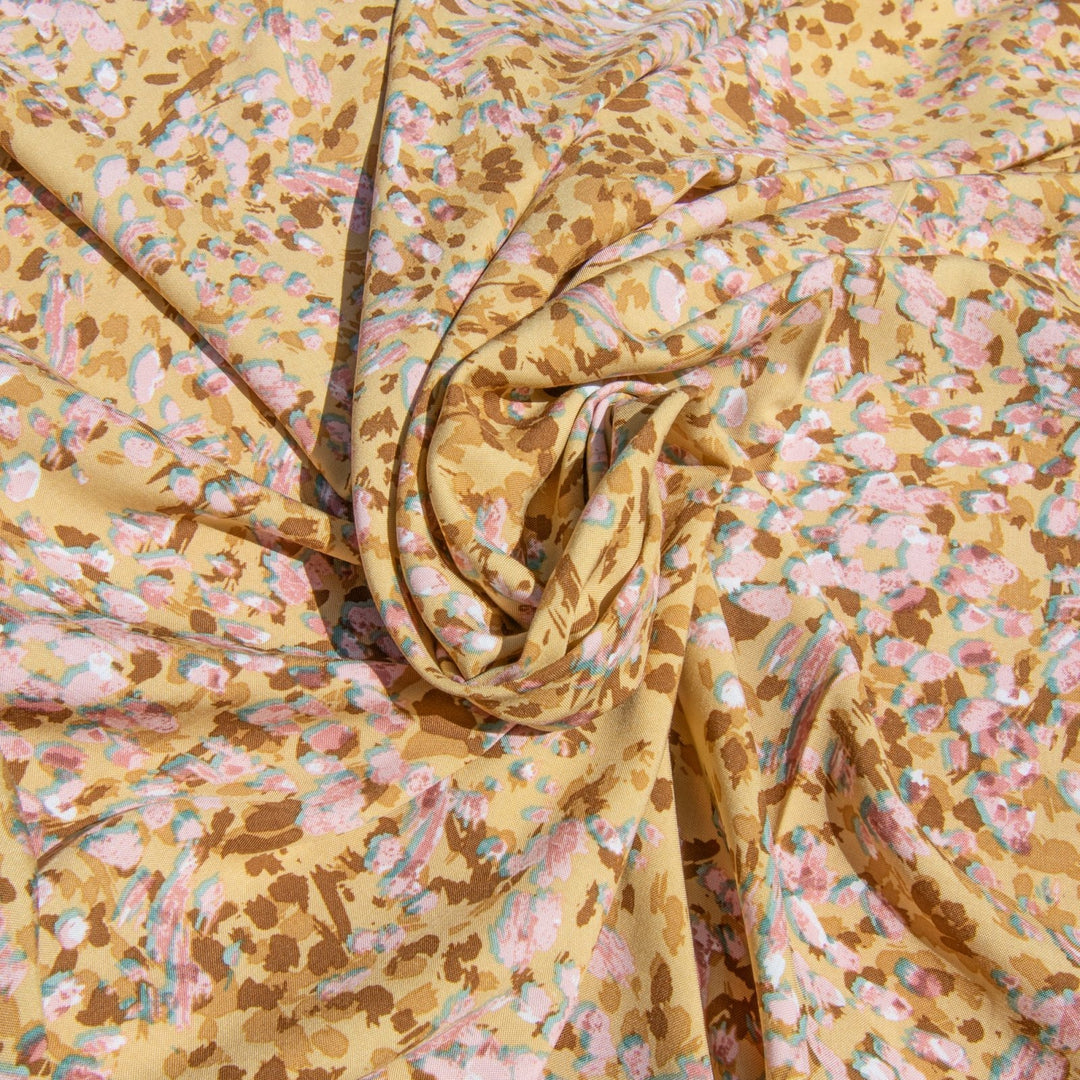 Rayon Challis fabric in buttery caramel abstract pattern, 56-inch wide, lightweight and flowing, ideal for dresses and blouses.