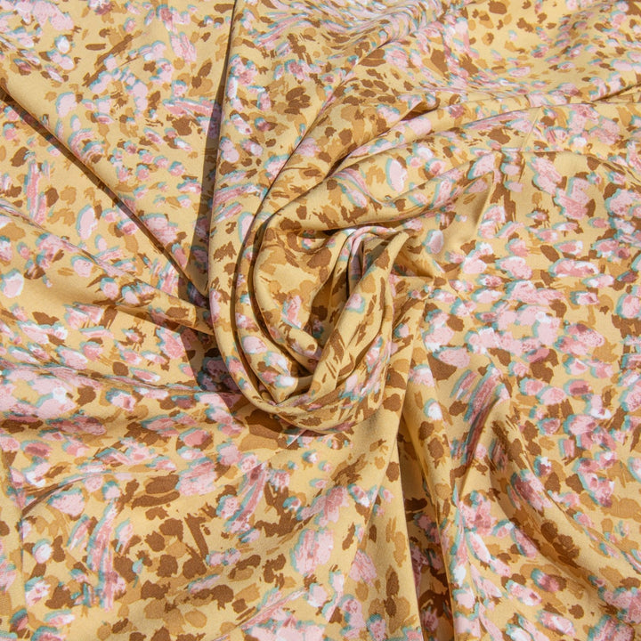 Rayon Challis fabric in buttery caramel abstract pattern, 56-inch wide, lightweight and flowing, ideal for dresses and blouses.