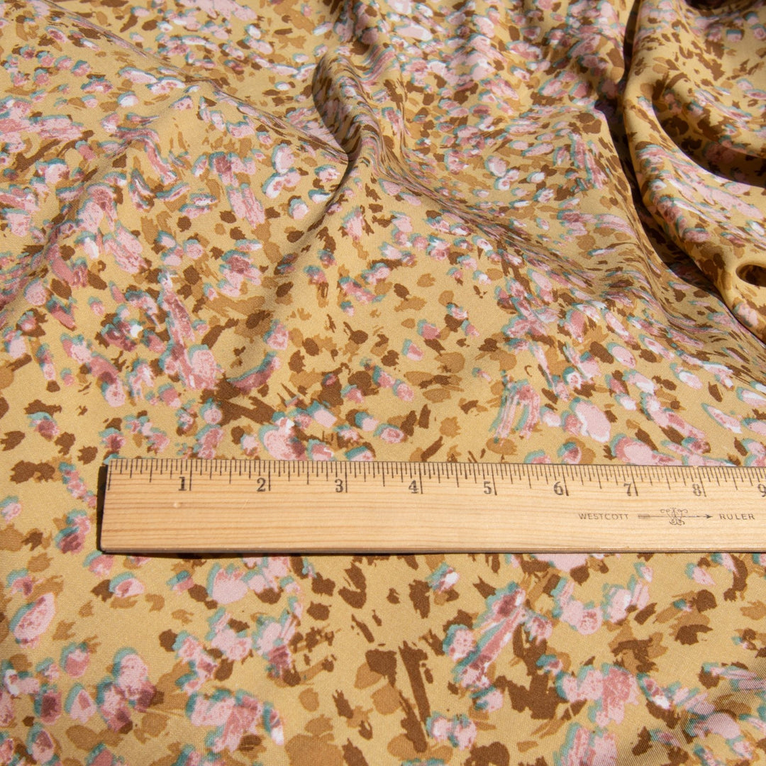 Rayon Challis fabric in buttery caramel abstract pattern, 56-inch wide, lightweight and flowing, ideal for dresses and blouses.