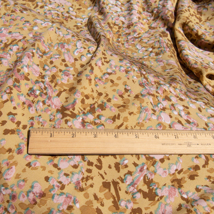 Rayon Challis fabric in buttery caramel abstract pattern, 56-inch wide, lightweight and flowing, ideal for dresses and blouses.